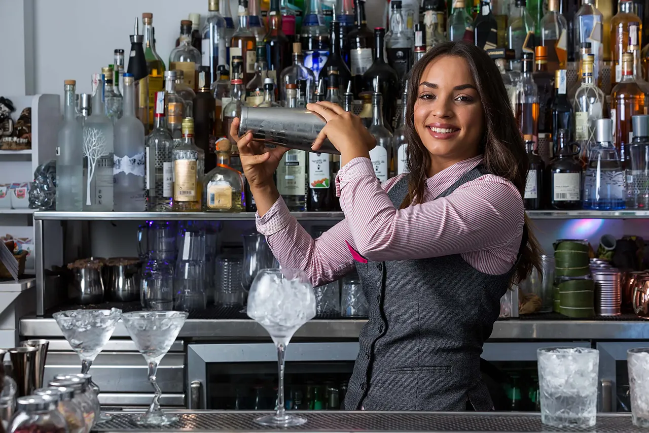 Female African American bartender shaking a drink